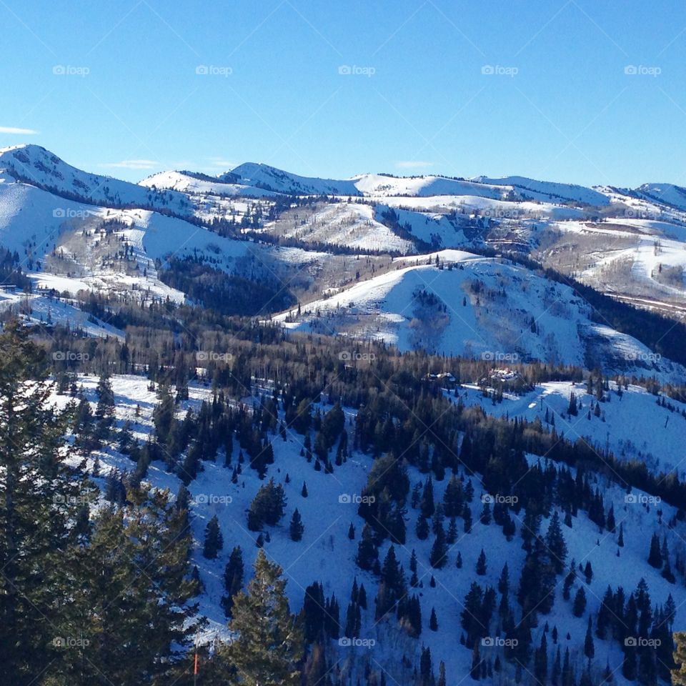 Sun and Snow. Sun kisses the top of snow-covered mountains, shadowed on the other side