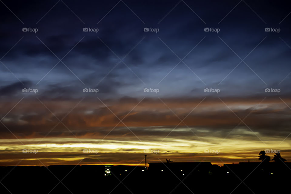 Beautiful light of Sunset with clouds in the sky reflection behind the building.