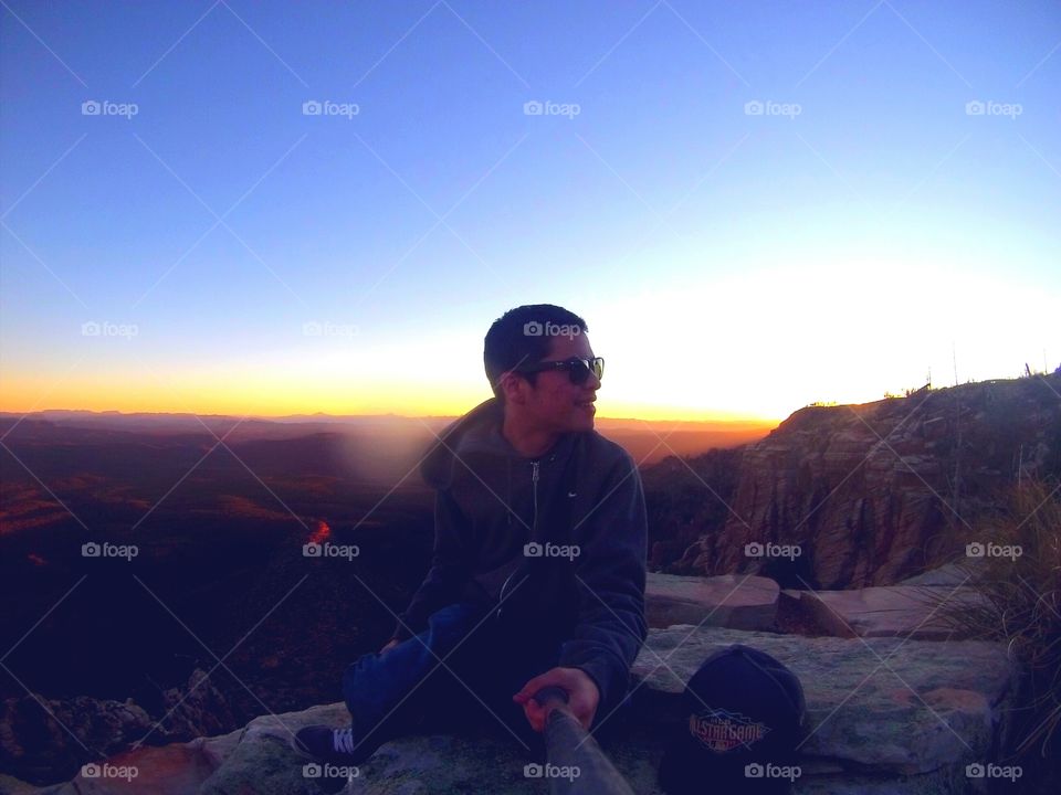 Man sitting on hill at sunset