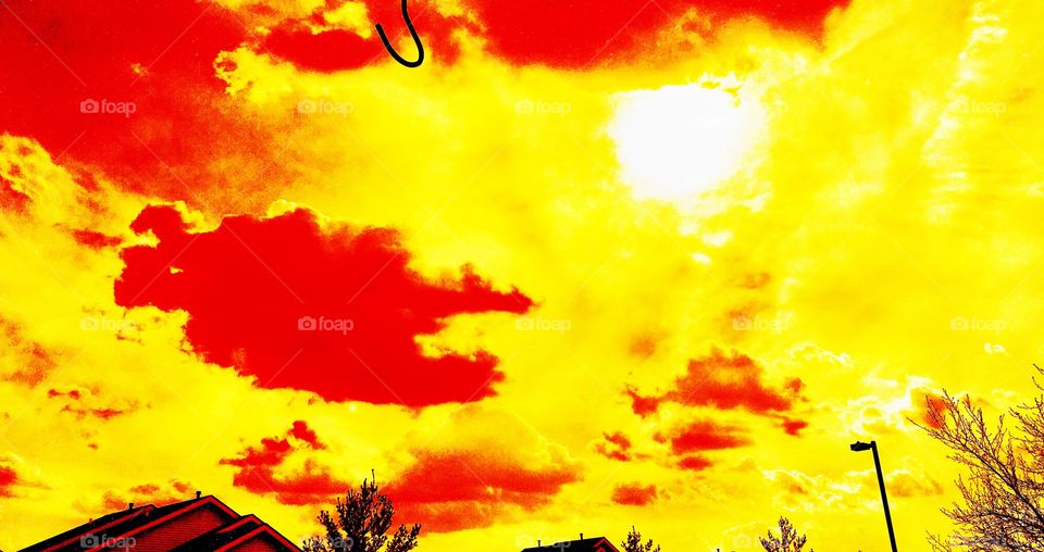Fire in the sky; orange sunglasses facing clouds on a Warm March Spring Day with Puffy Orange Clouds on Burnt Orange Sky
