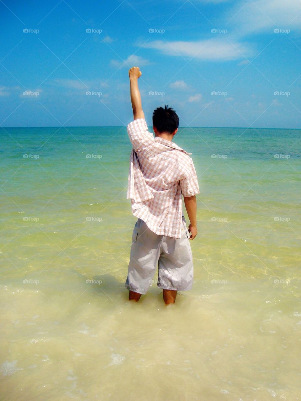 Asian boy standing in the sea