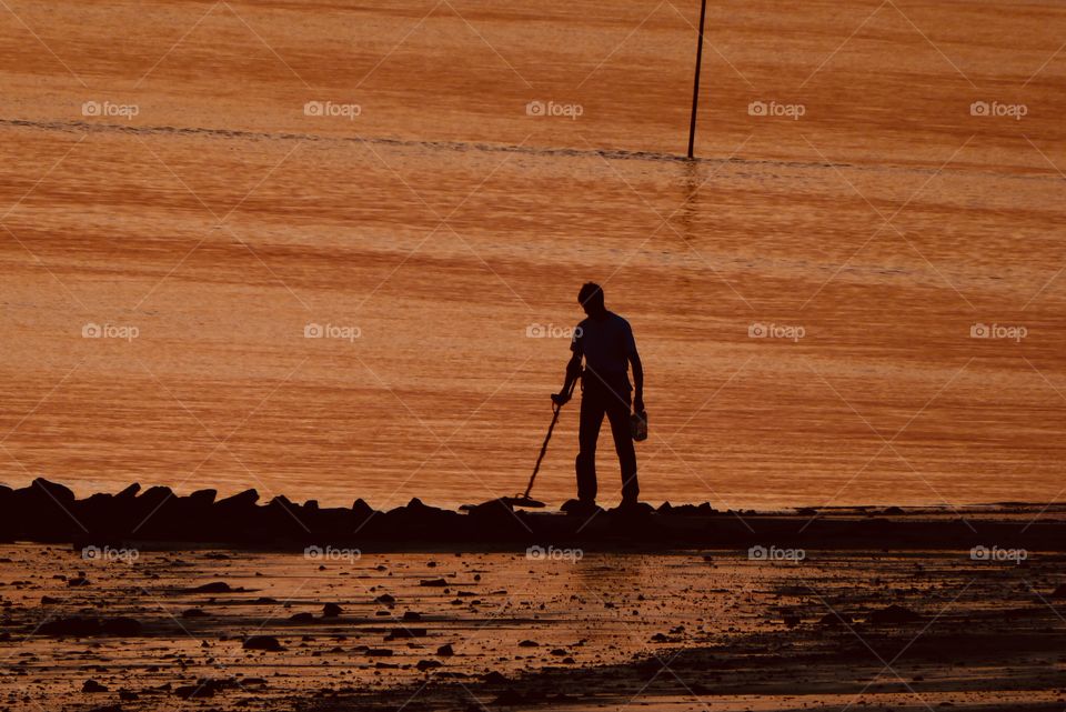 treasure seeker at the Beach at sunset 