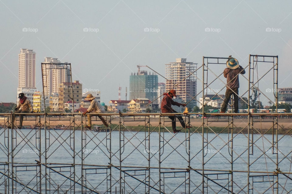 Men hard at work disassembling one of the many large floats from the river festival in Phnom Penh, Cambodia 