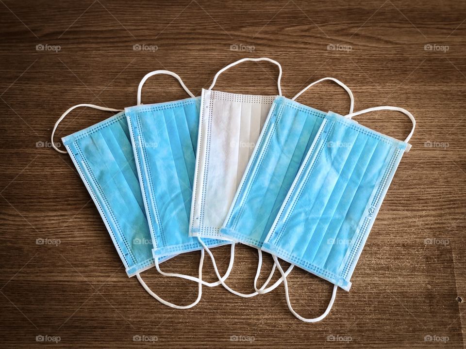 Multiple surgical masks on wooden table