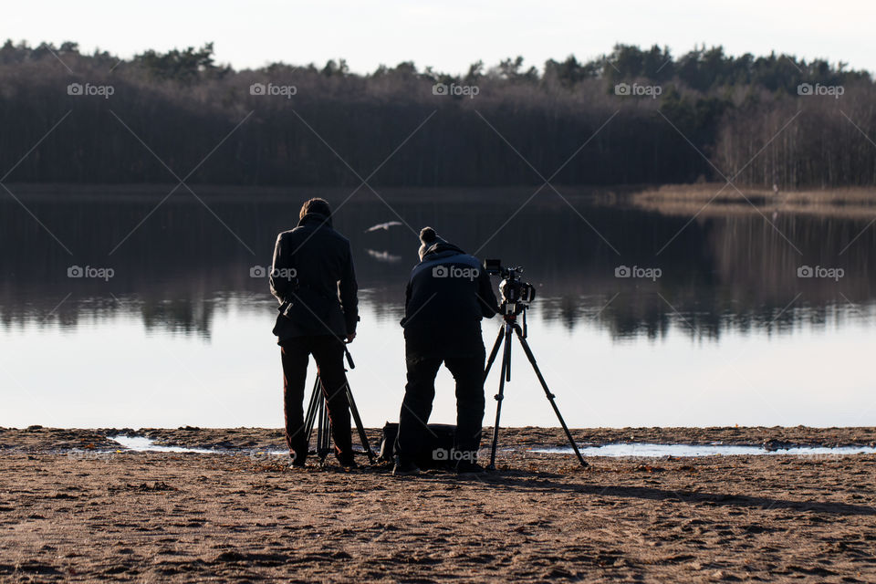 Photographers in action taking pictures of bird landing on the water - Fotografer fotograferar fågel som landar på vatten 