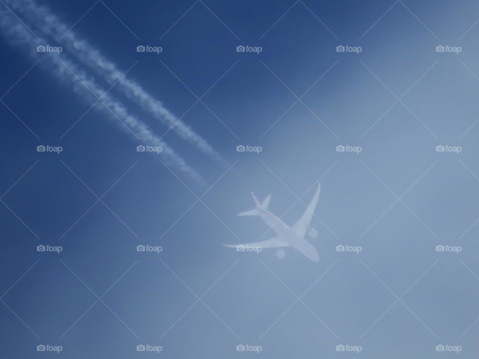 American Airlines Aircraft with Contrail Entering the Clouds