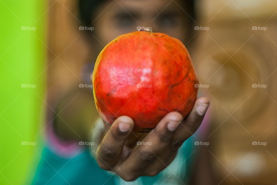 Girl holding pomegranate fruit in hand