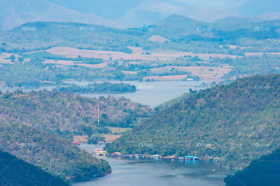 The beauty inside the dam and the houseboat on the bright sky at Sri Nakarin dam , Kanchana buri in Thailand.