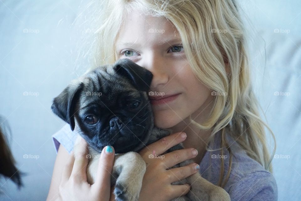 Snuggle Sunday’s! Adorable daughter with our pug puppy Eleanor 