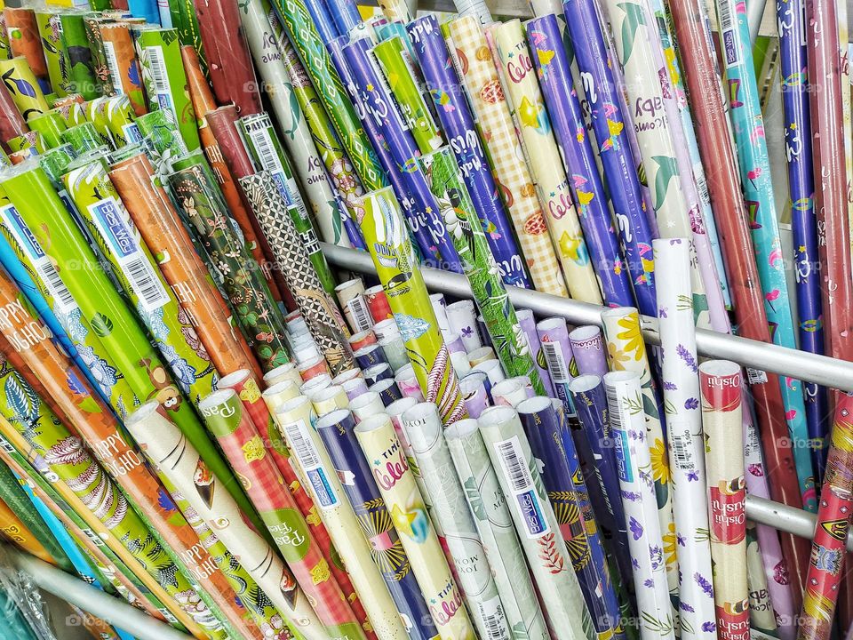 Rolls of colorful wrapping paper for sale at a stationery shop