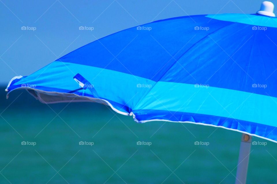 Bright blue umbrella against the ocean