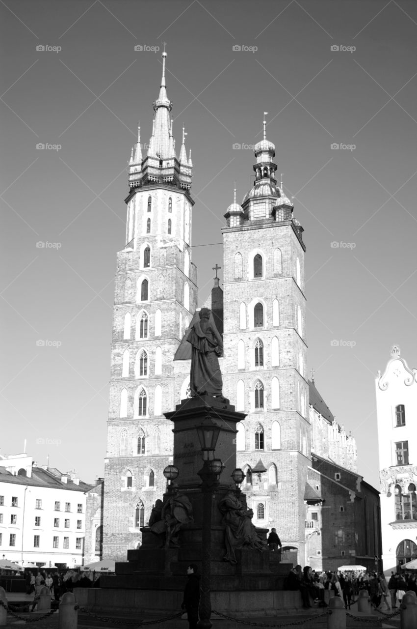 Old town square Kraków, the statue of Adam Mickiewicz looking towards the St. Mary's Basilica.