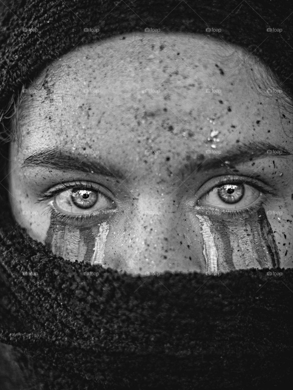 Black and white photograph of a sad girl, with tears and shocking eyes