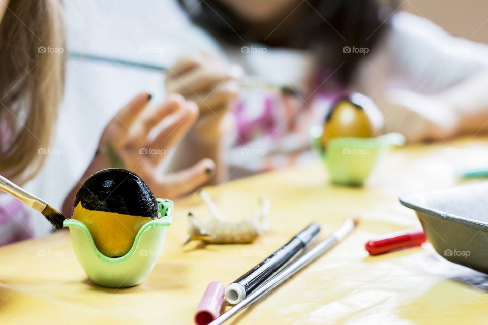 Children drawing on eggs for Easter