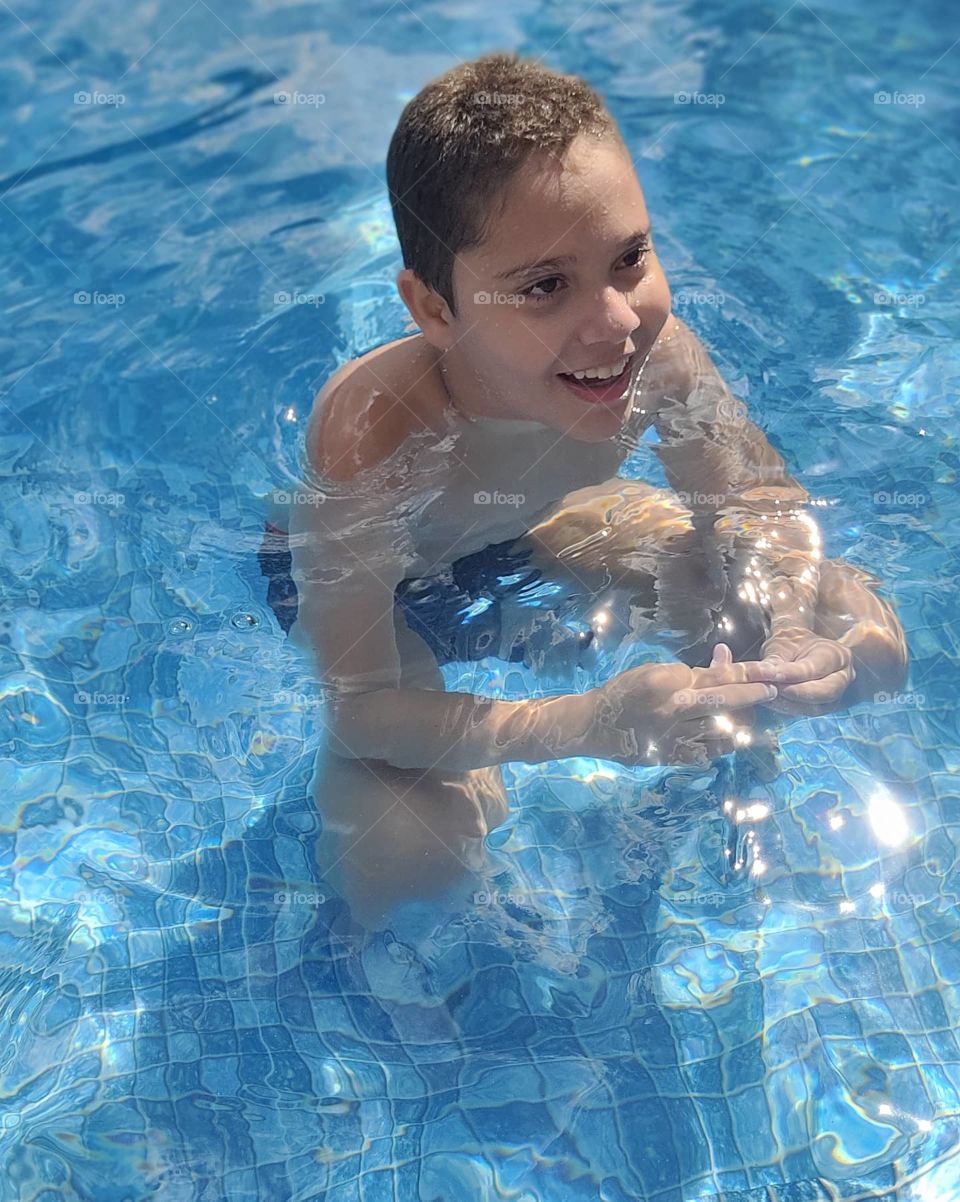 Filhão curtindo uma piscina.