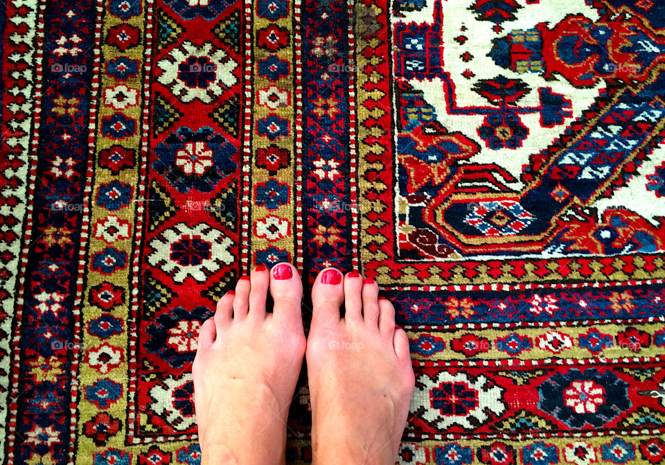 Standing barefoot on the old Persian rug. 