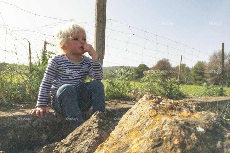 Boy sitting on a wall