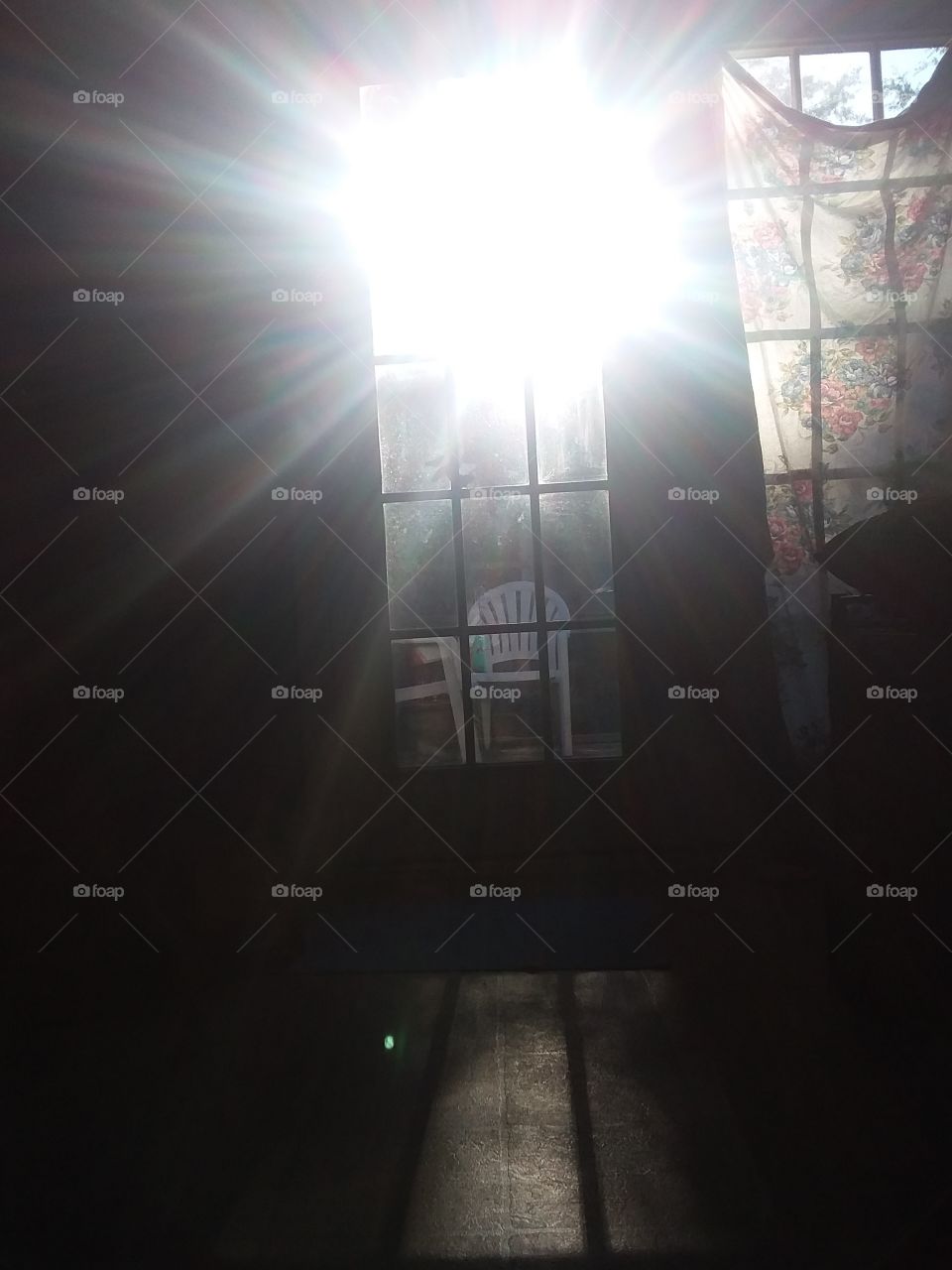 sun setting shines through the window and across the room  casting light and shadows throughout