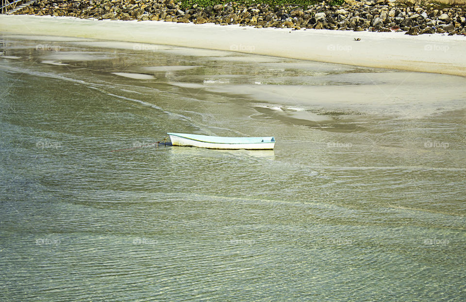 Fiberglass boat parked on the Beach And garbage on the rocks at Koh Phangan, Surat Thani in Thailand.