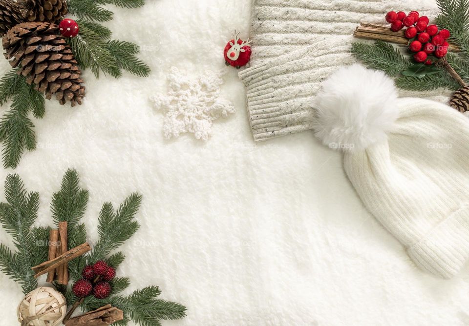 Winter white flat lay on soft blanket with winter woollies and christmasy decorations