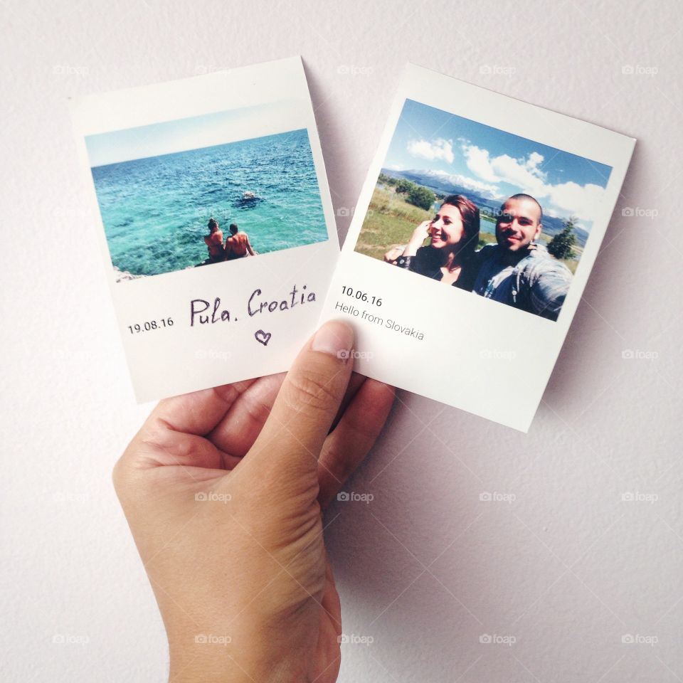 Elevated view of a human hand holding photographs