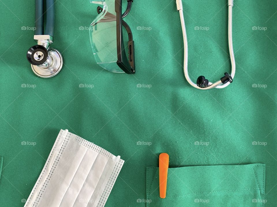 Health professional material: Medical scrub, pen, surgical mask, stethoscope and protective glasses