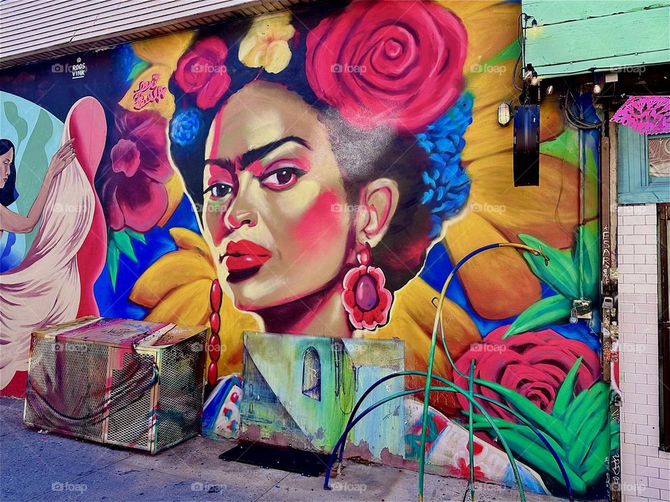 This mulatto lady with flowers in her hair adorns the facade of “Jefferson St” off “B’way” in “Bushwick”, Bklyn by “La Lupe” club restaurant. The mural celebrates Latin “PRIDE” and extends over almost an entire city block. 2024. Hypnotic Productions