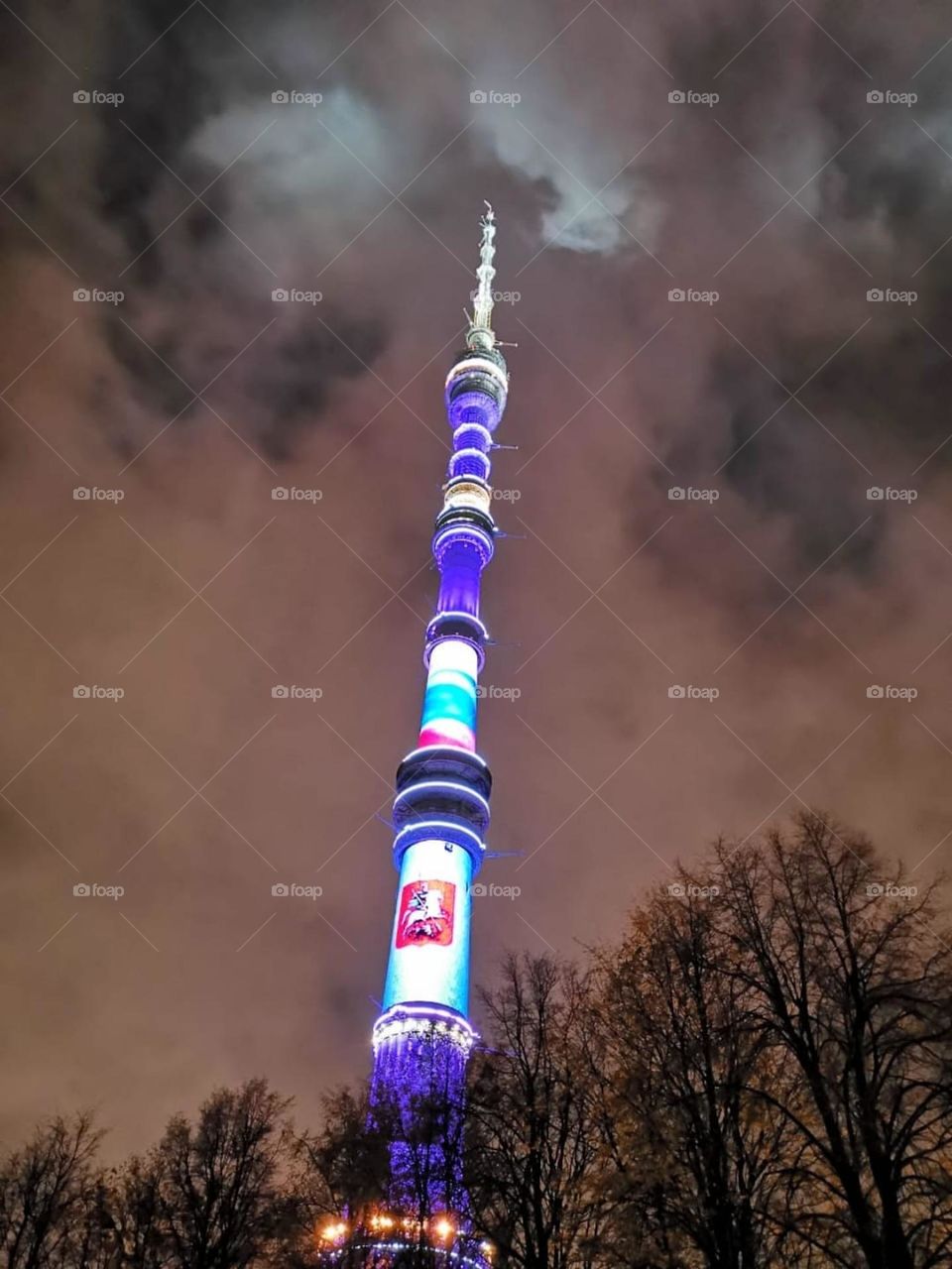 The Ostankino TV tower illuminated in different shades of purple.  Moscow.  Height 510.1 m. 120 floors