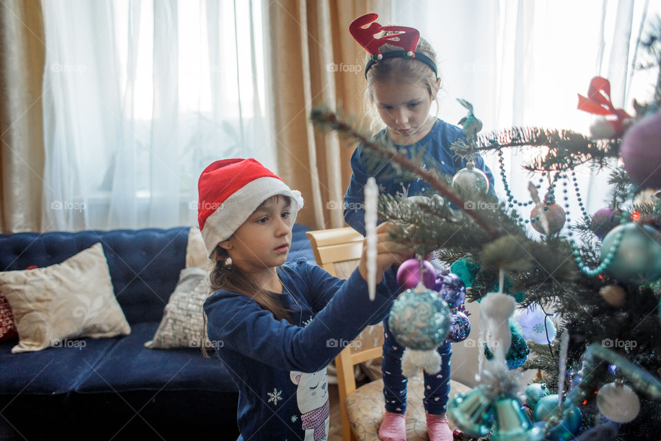 Little sisters with German shepherd puppy near Christmas tree 