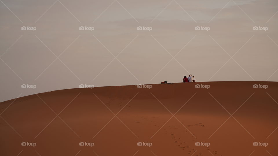 pareja viendo amanecer en el desierto