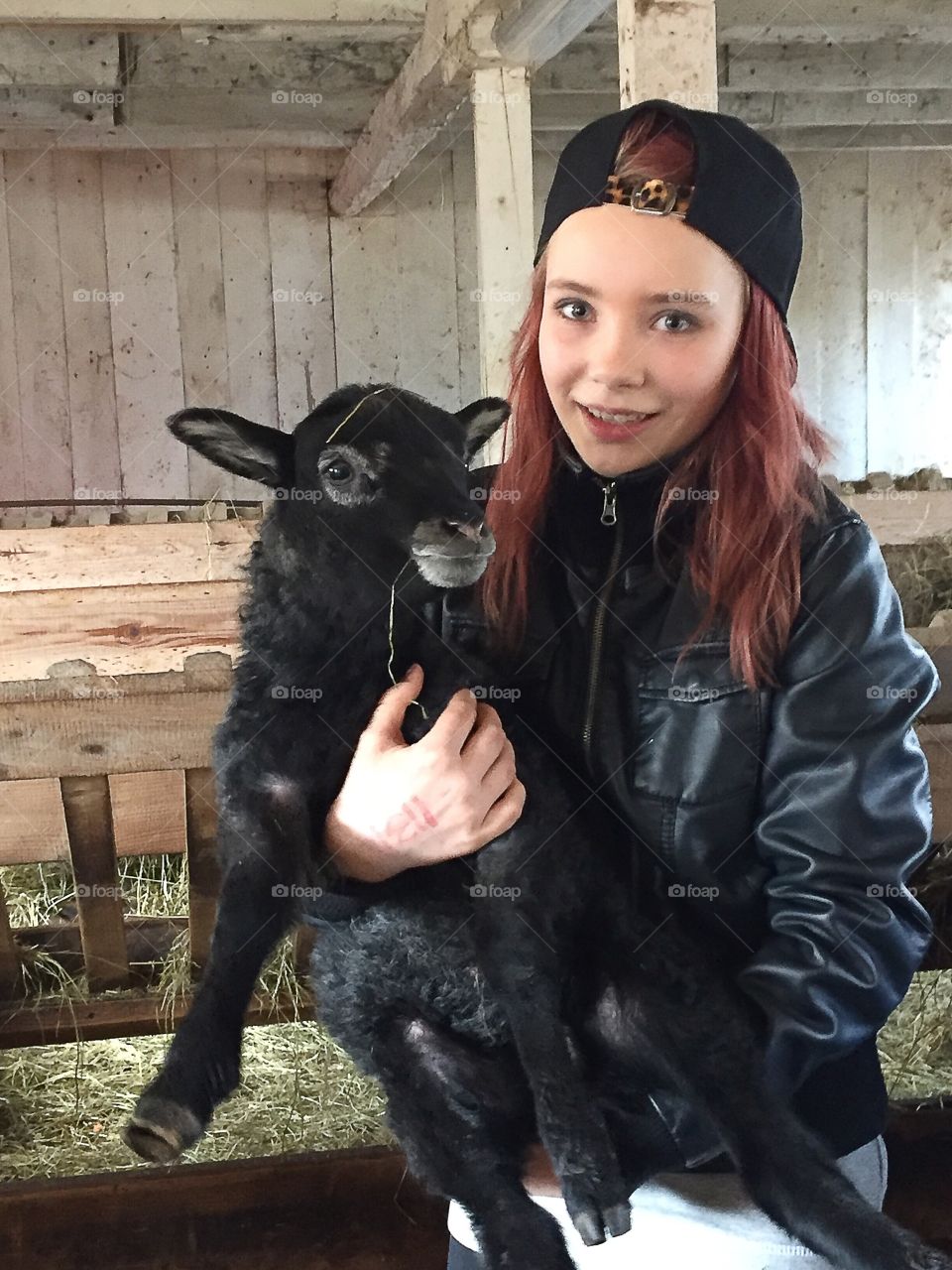 Close-up of a teenage girl carrying baby goat
