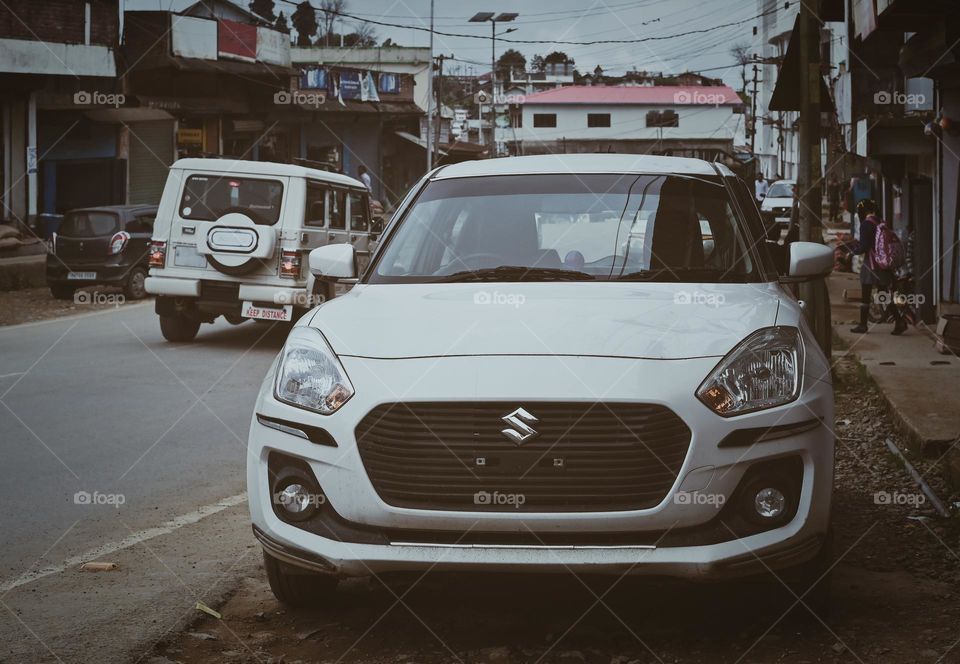 A white car by the side of a road