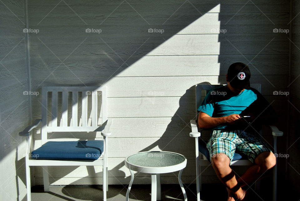 Man wearing cap using mobile phone