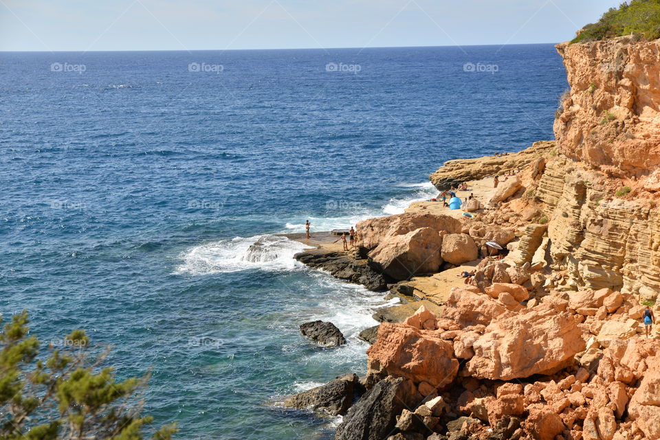 People near a cliff at sea