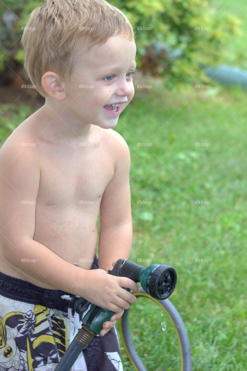 Close-up of boy holding pipe hose