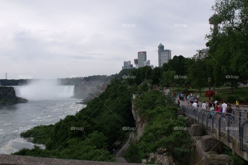 An average summer day in Niagara Falls, ON.  Horseshoe Falls to the left.  Tourists to the right.