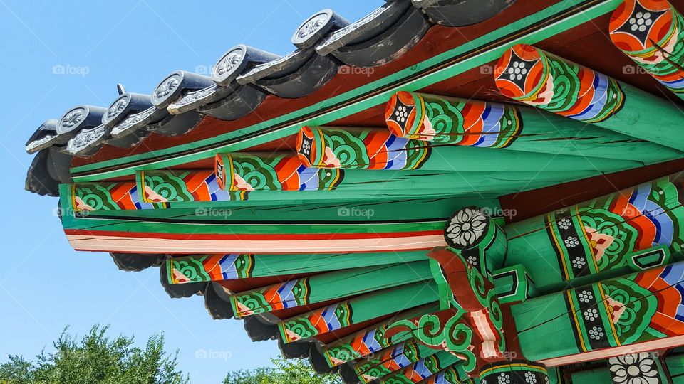 part of the roof traditional Korean wooden gazebo with painted ornament and bell inside
