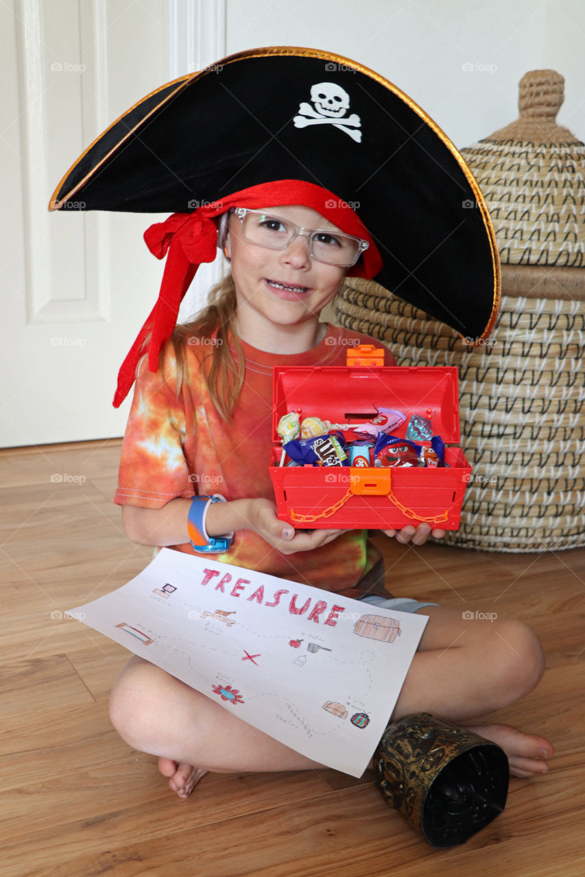 Child dressed as pirate showing off her treasure and treasure map