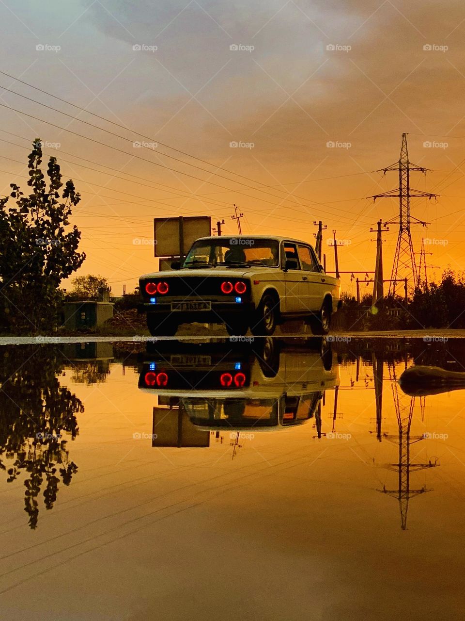 Orange sky yellow car red lights 