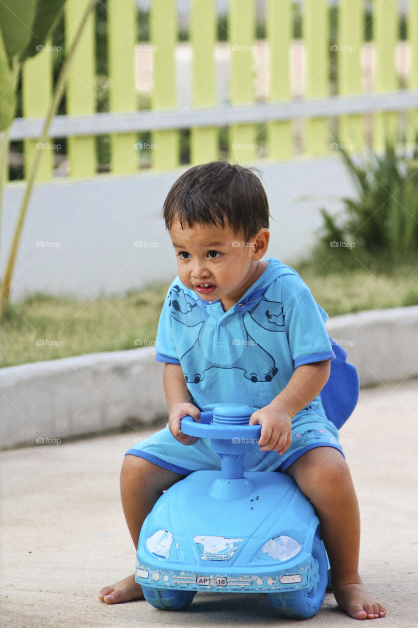 Kid riding toy car. outdoor fun