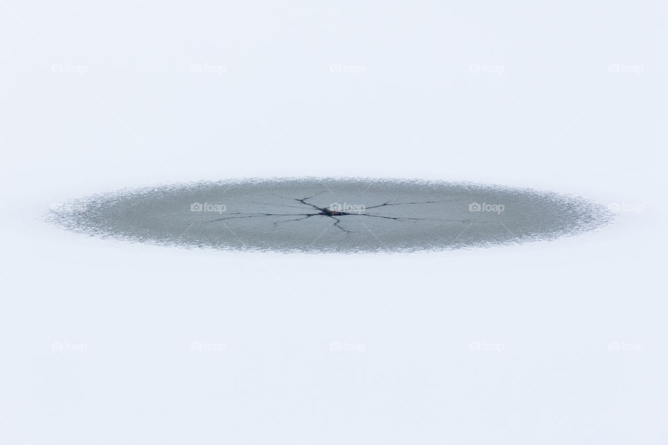 Round symmetric hole in the ice , open lake water in the middle, pattern 