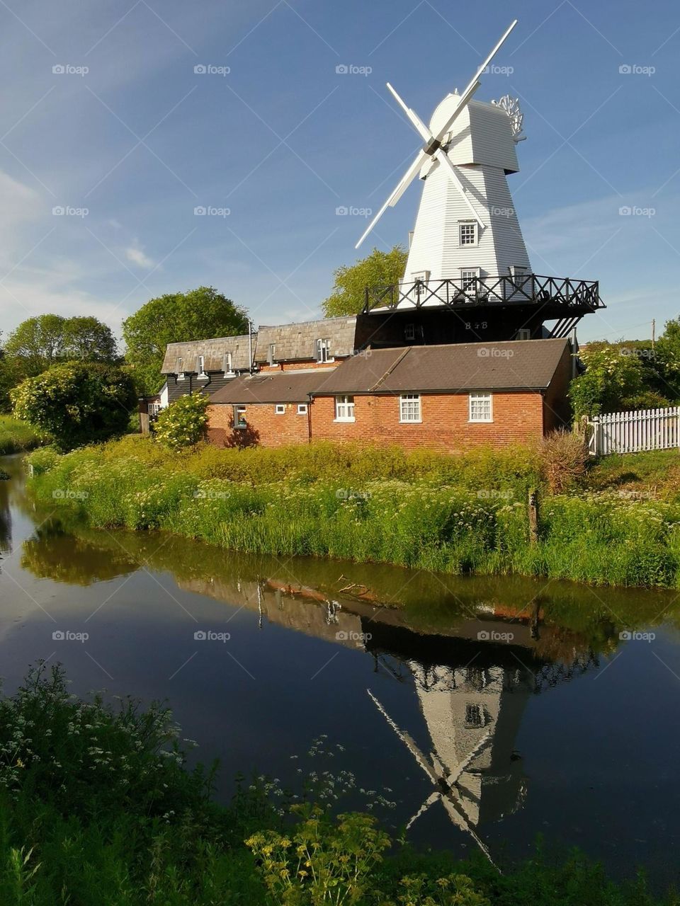 Country side. Windmill. River. Summer time.