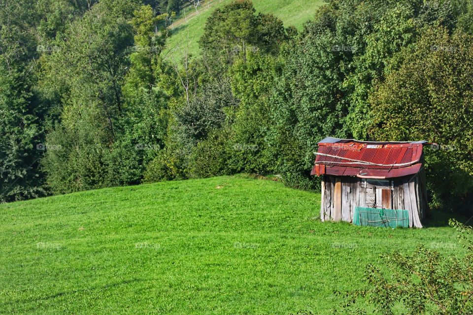 Old barn on a green mountain slope 