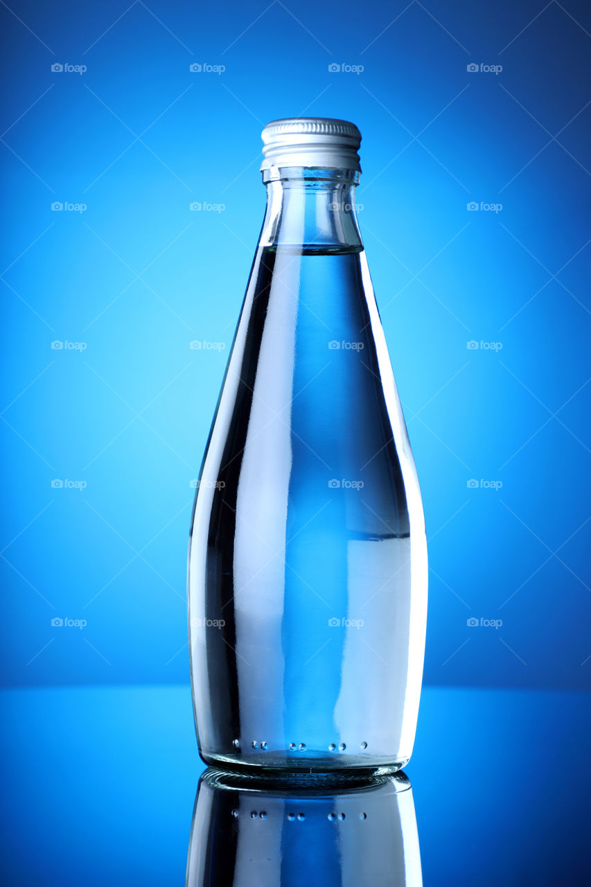 Clean and pure mineral drinking water bottle on blue background
