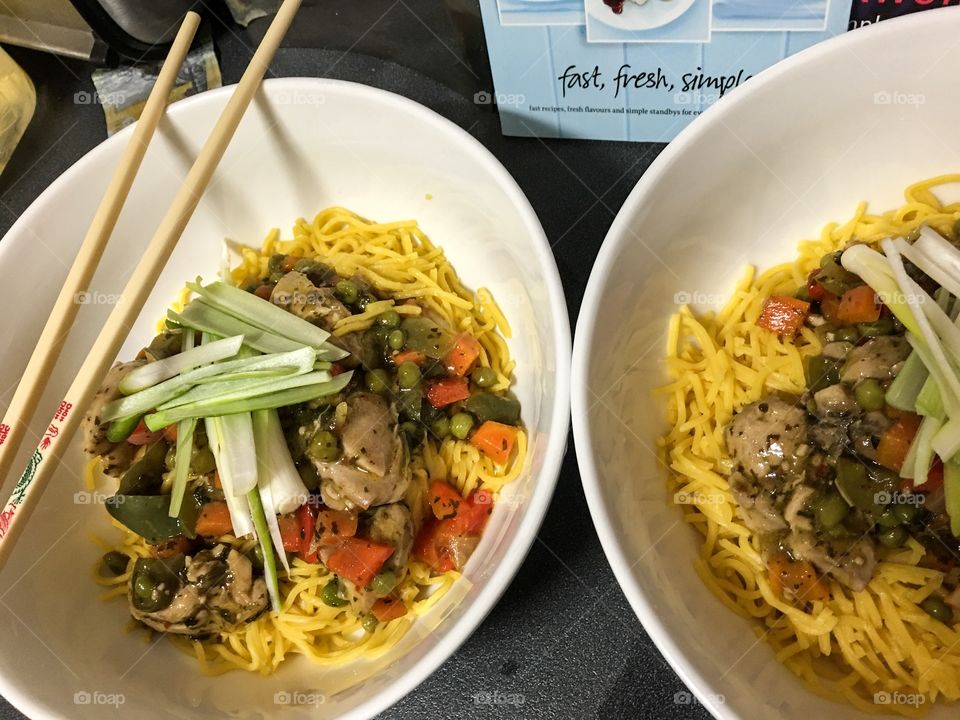 Asian food in white bowls chopsticks closeup 