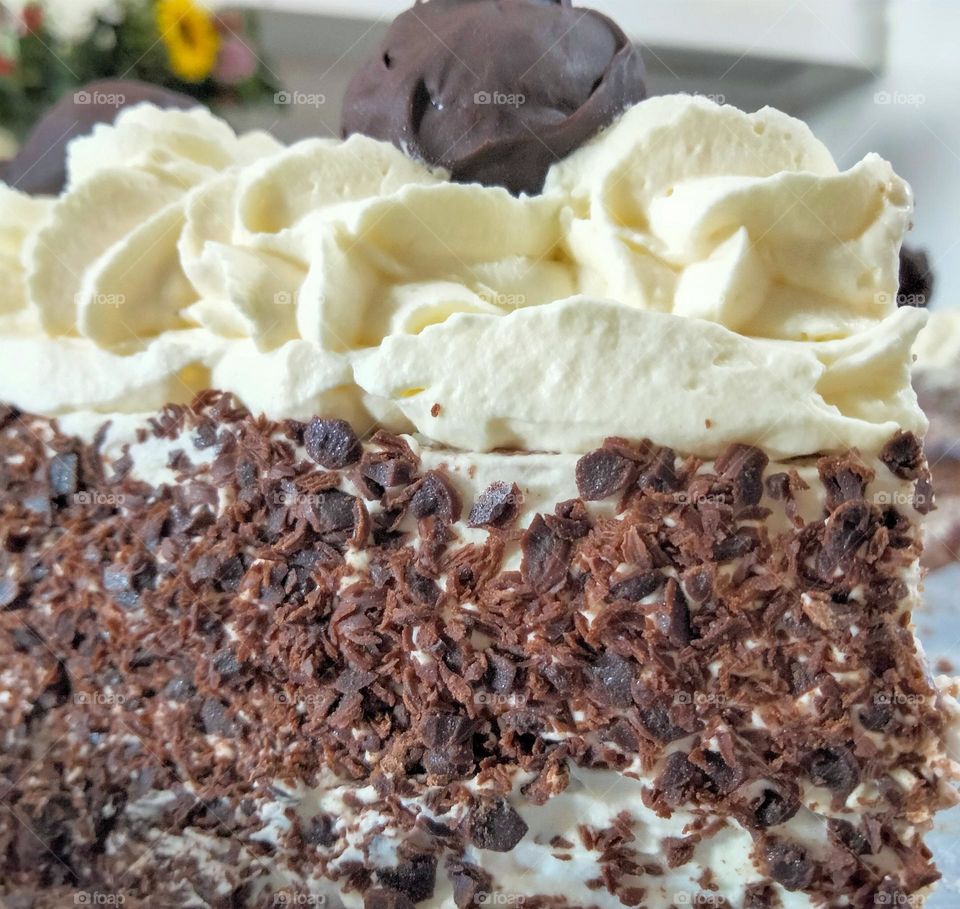 a slice of cake with cream and chocolate bits