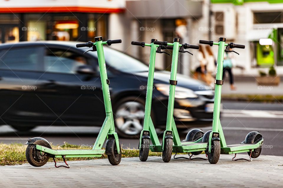 Several electric scooters against the backdrop of a moving car.