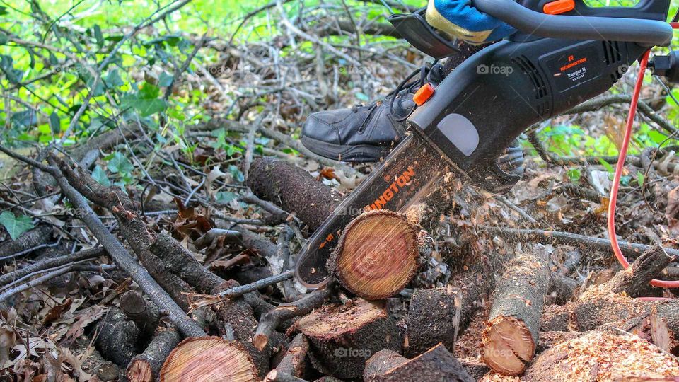 Cutting logs with a Remington electric chainsaw