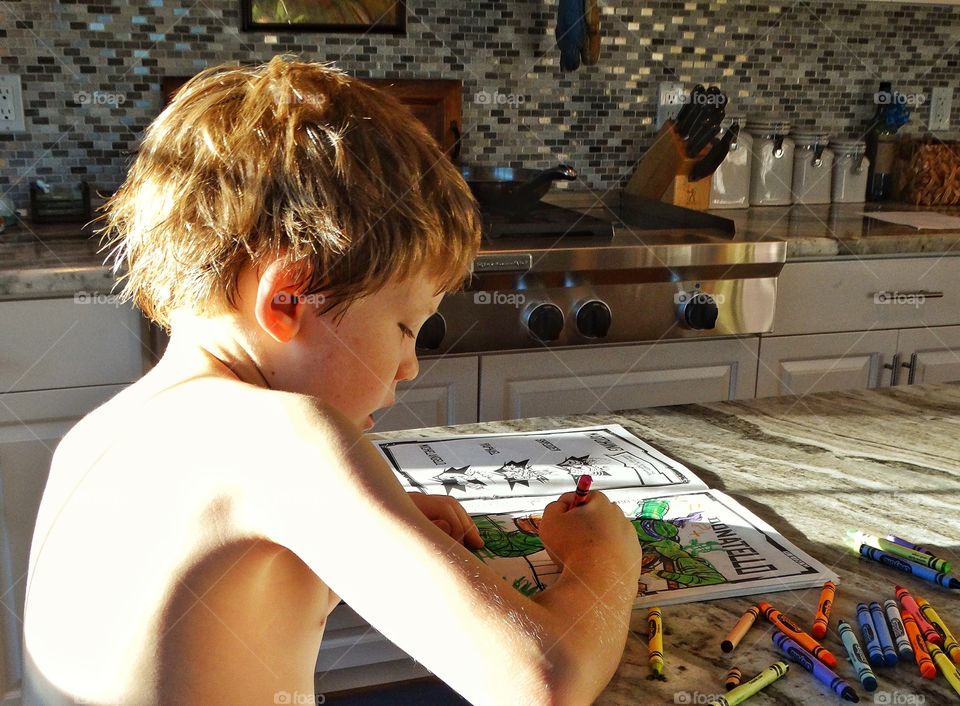 Young Boy Drawing In A Coloring Book
