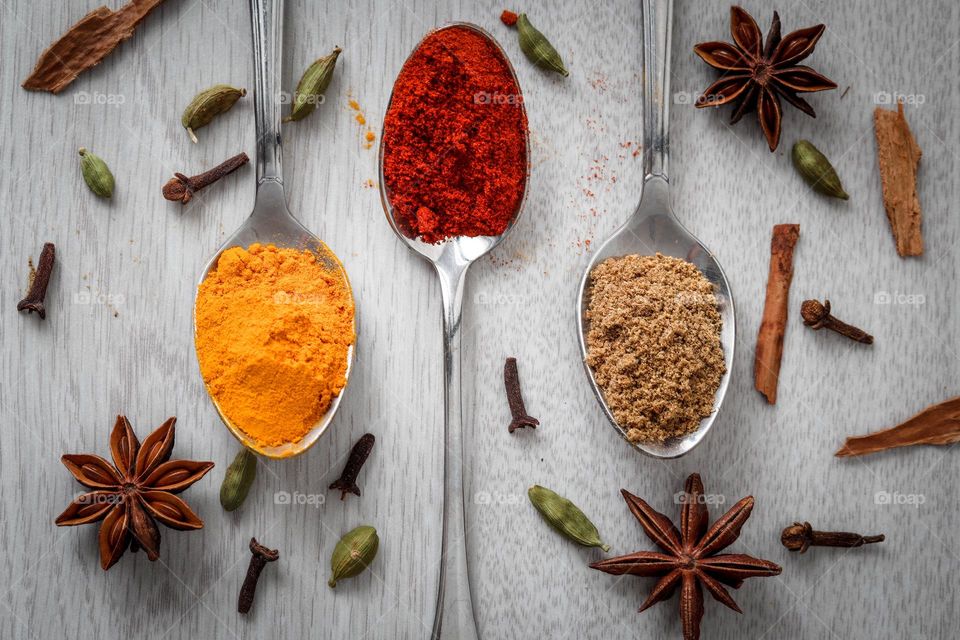 Metal spoons and colorful spices